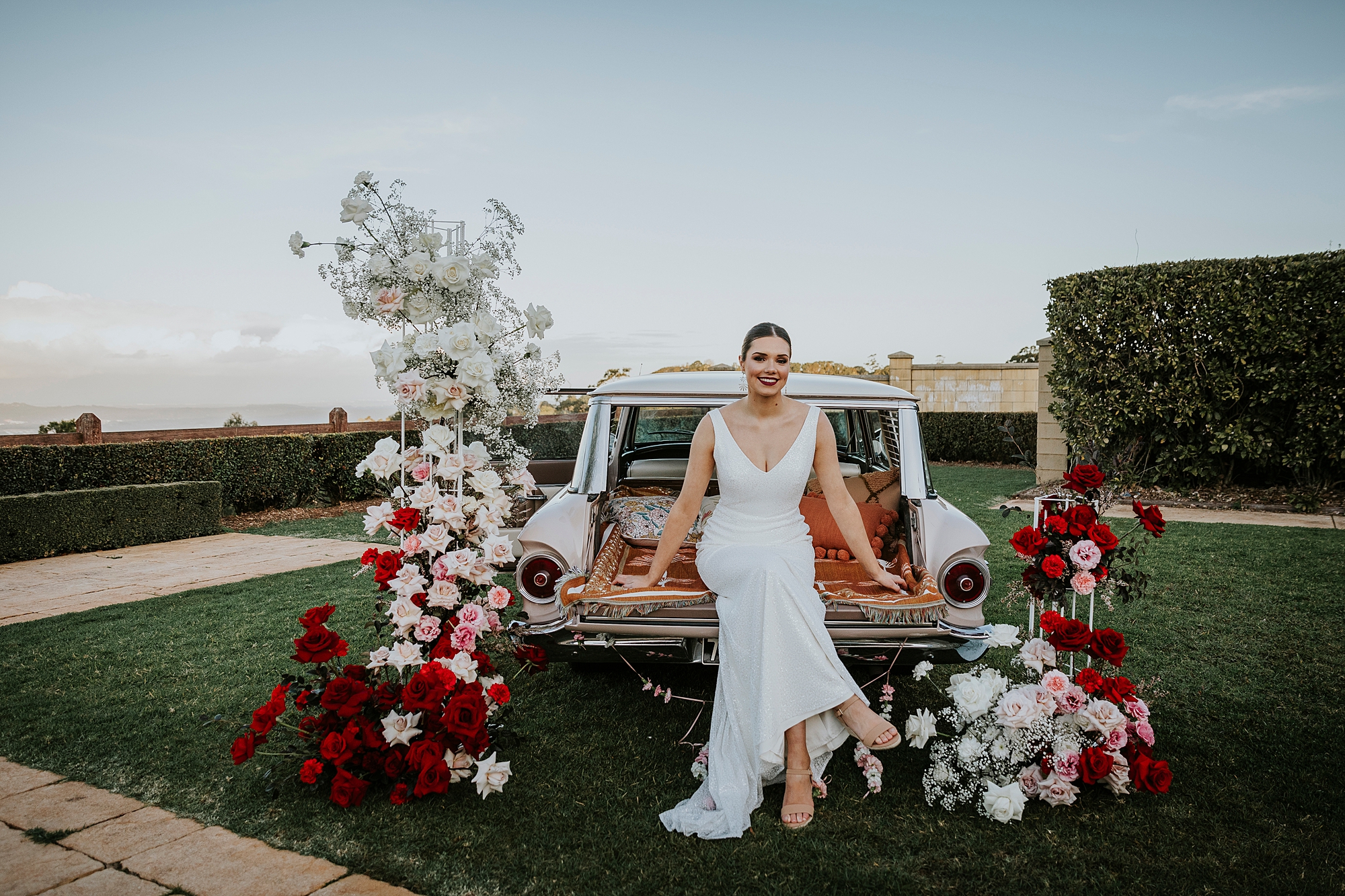 Bride sitting on vintage car